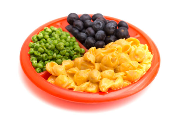 child's meal of macoroni shells and cheese, peas and blueberries - divided plate imagens e fotografias de stock