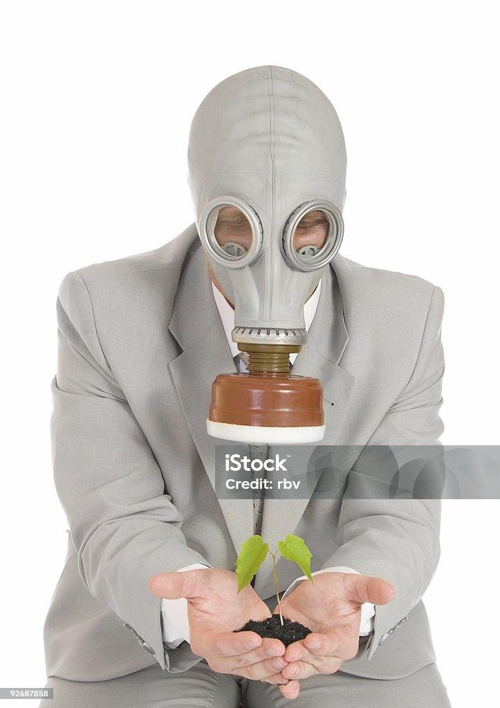 Hombre de la máscara de gas sosteniendo planta verde - Foto de stock de Adulto libre de derechos