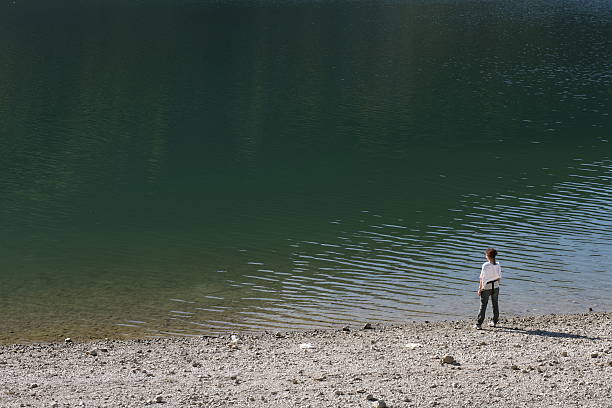 Girl on a lake beach stock photo