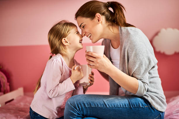 Young mother and her daughter at home having fun time together.