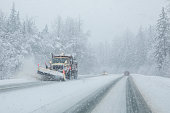 Snow plow clearing highway during snow storm.