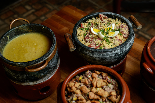 Side dishes of Brazilian feijoada on the rustic table.