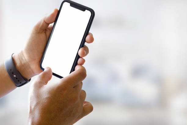 istock Mobile phone in man's hand, Smartphone showing blank screen for graphic display montage. 926899042