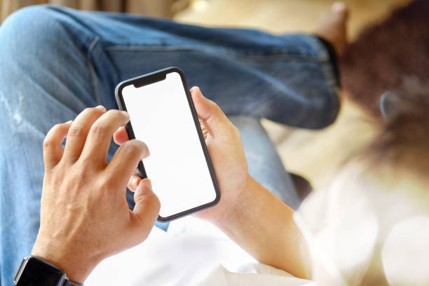 istock Mobile phone in man's hand, Smartphone showing blank screen for graphic display montage. 926899064