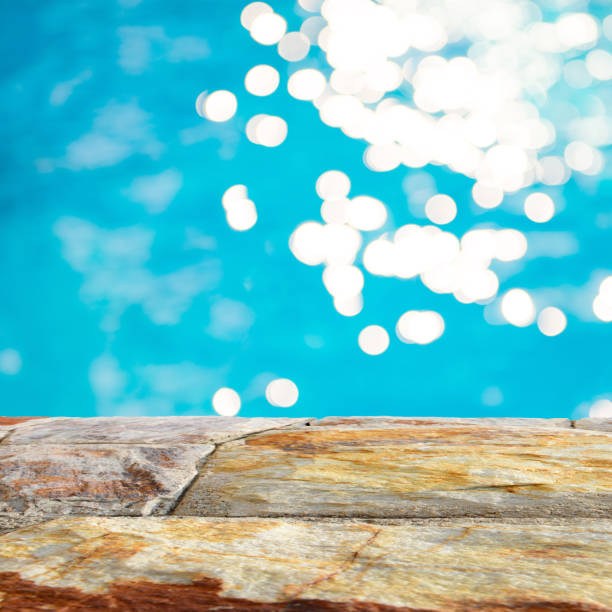 istock Brown stone table top and blurry blue water bokeh abstract background, product display montage 926899628