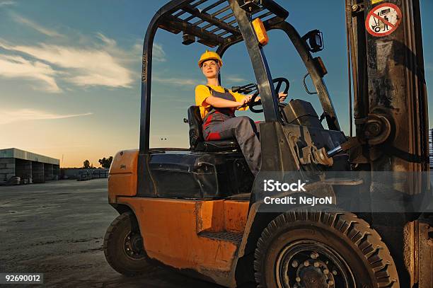 A Worker Operating A Forklift At Dusk Stock Photo - Download Image Now - Forklift, Women, Driving