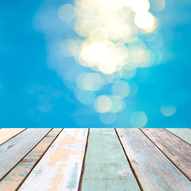 istock Perspective wood table top and blurry blue water bokeh abstract background, product display montage 926901868