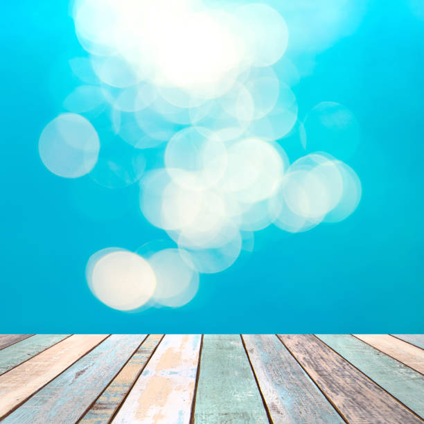 istock Perspective wood table top and blurry blue water bokeh abstract background, product display montage 926902048