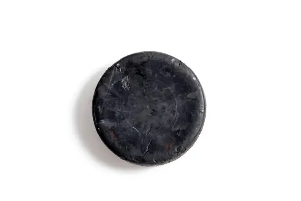 Close up shot of a hockey puck on a white background