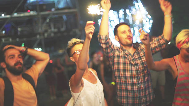 istock Friends holding sparkles at concert 926914580