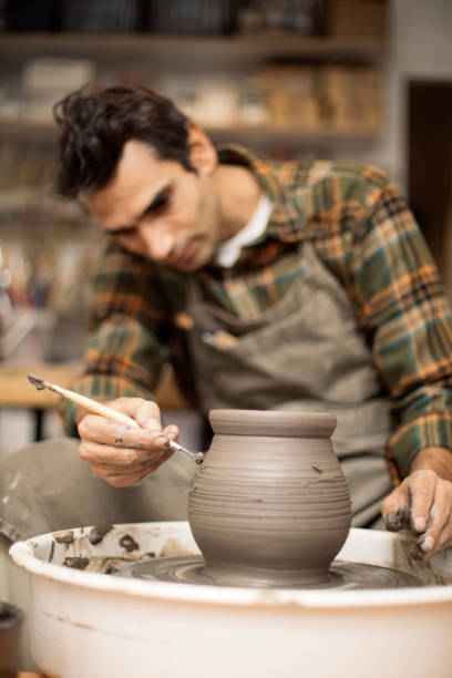 istock Artist makes clay pottery on a spin wheel 926917238