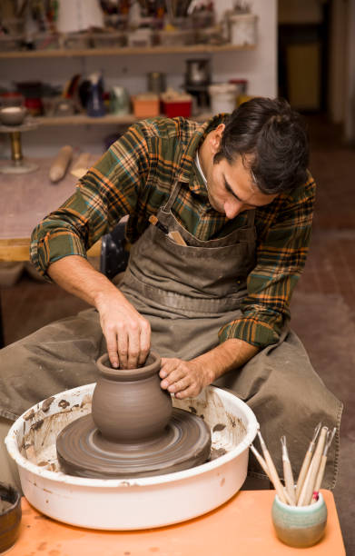 istock Artist makes clay pottery on a spin wheel 926917246