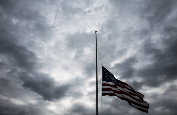 istock American Flag lowered to Half-Mast remembering those who served with a dramatic cloud background 926921726