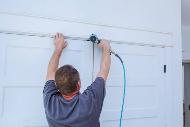 istock Carpenter brad using nail gun to moldings on doors, framing trim, with the warning label that all power tools 926927796