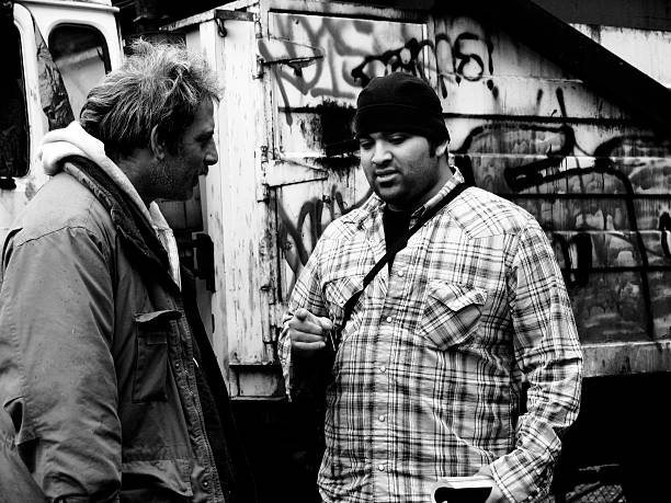 Young Man Teaching Homeless Guy stock photo