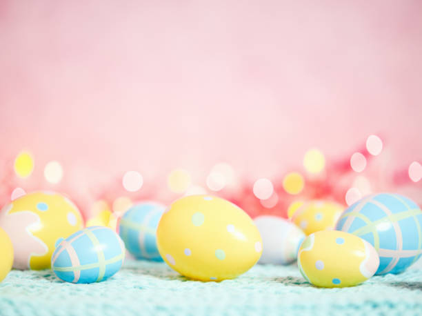 istock Pastel pink bokeh background with yellow and blue eggs for Easter 926943328