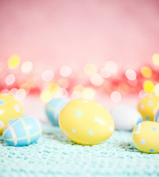 istock Pastel pink bokeh background with yellow and blue eggs for Easter 926943330