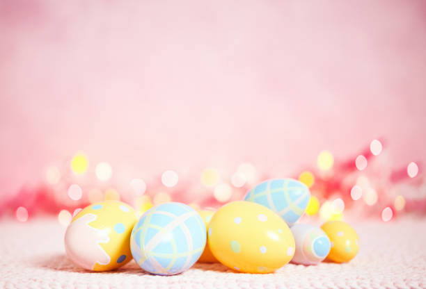 istock Pastel pink bokeh background with yellow and blue eggs for Easter 926943334