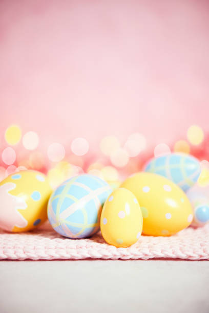 istock Pastel pink bokeh background with yellow and blue eggs for Easter 926943374