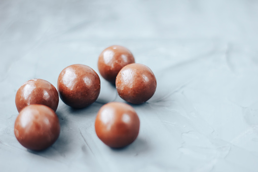 round chocolate bon-bons. sweets Chocolate Dragees on Grey Background