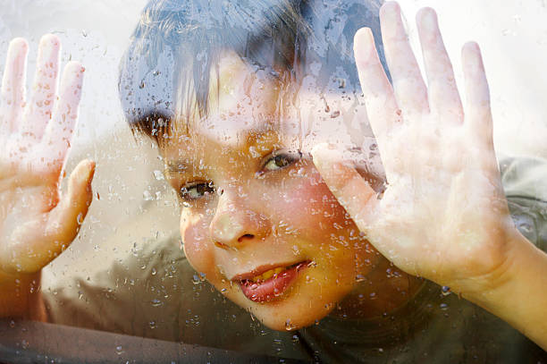istock child and window on a wet rainy day 92695336