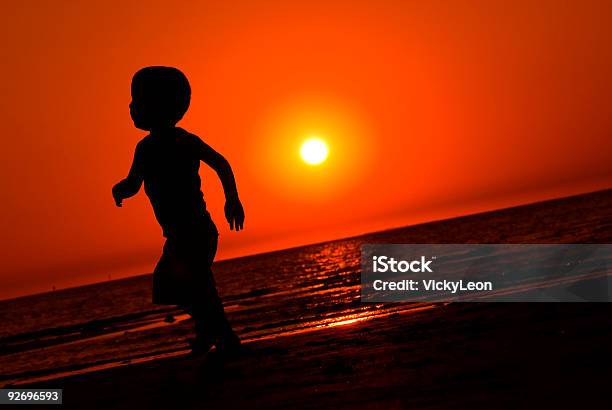 Foto de Menino Correndo No Pôr Do Sol e mais fotos de stock de Correr - Correr, Criança, Silhueta