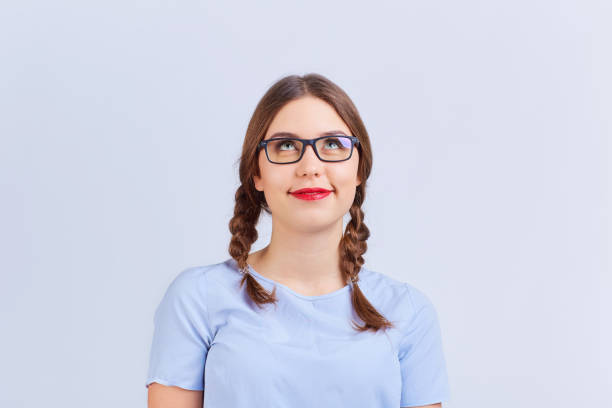 istock A young girl in pigtail glasses thinks, dreams with a positive e 926971144