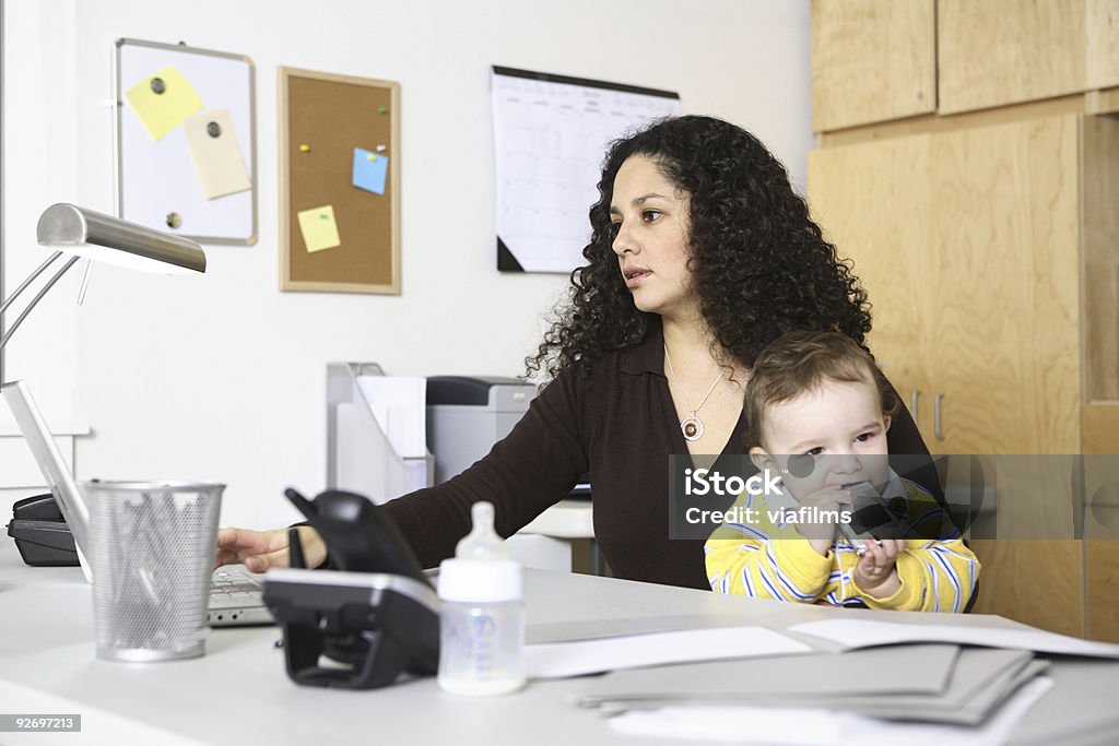 Woman in home office with child  Adult Stock Photo