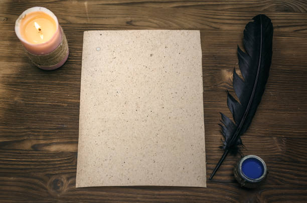 istock Empty blank paper page sheet with copy space, feather pen and inkstand  on wooden table background. Education background. Back to school. The ancient letter template. 926974726
