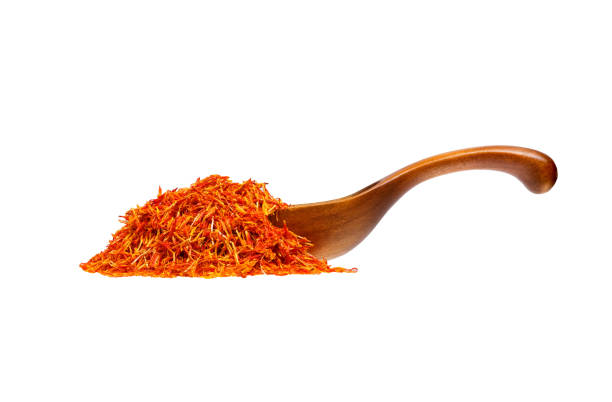 Saffron stamens in the wooden spoon, isolated on white background.