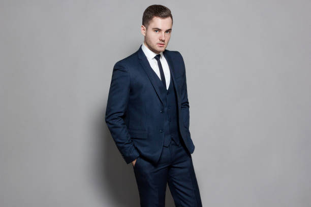 istock man in blue suit with vest in studio on gray background 927000090