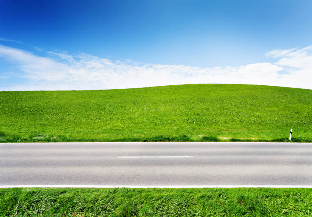 strada verde collina e asfalto, vista laterale - ciglio della strada foto e immagini stock