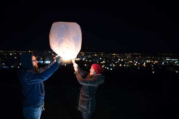 istock Young couple holding lantern with fire before to let it fly 927012830