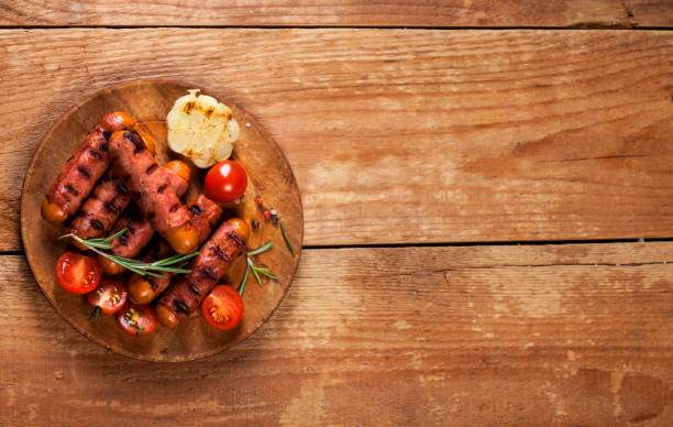 salsichas de cocktails festivas envolvidas em bacon defumado crocante, comumente conhecido como 'porcos em cobertores' em fundo de madeira - blanket pig hot dog sausage - fotografias e filmes do acervo