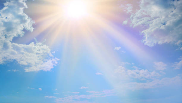 Miraculous Heavenly Light Blue sky, fluffy clouds and a beautiful warm orange yellow sun beaming down radiating depicting a holy entity miracle stock pictures, royalty-free photos & images