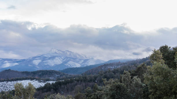 istock Snowy peak mountains on a winter cloudscape landscape 927028666