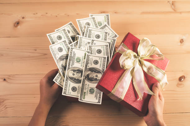 istock Money in red bow decorated gift box. 927030894