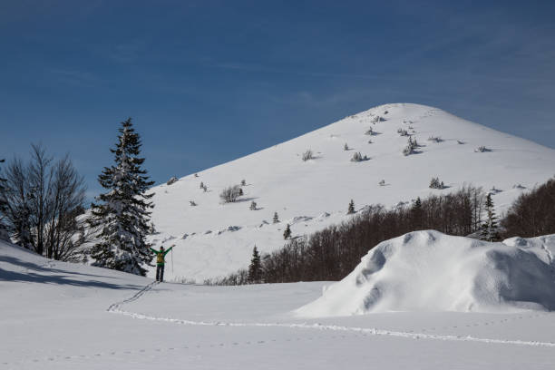 man on skis in awe of mountain peak - telemark skiing fotos imagens e fotografias de stock