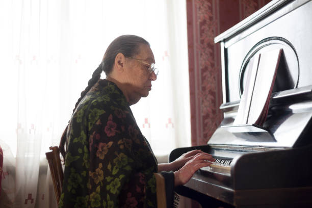 la vieja señora tocando música clásica en el piano de rareza en el país - rarity fotografías e imágenes de stock
