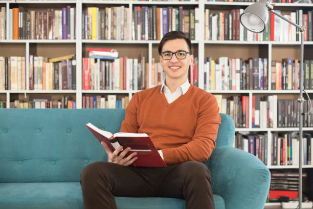 männliche schüler ein buch zu lesen - male education college student nerd stock-fotos und bilder