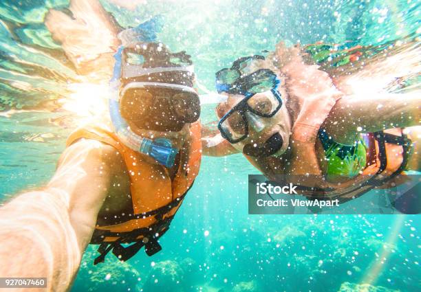 Senior Happy Couple Taking Selfie In Tropical Sea Excursion With Water Camera Boat Trip Snorkeling In Exotic Scenarios Active Retired Elderly And Fun Concept On Scuba Diving Warm Vivid Filter Stock Photo - Download Image Now