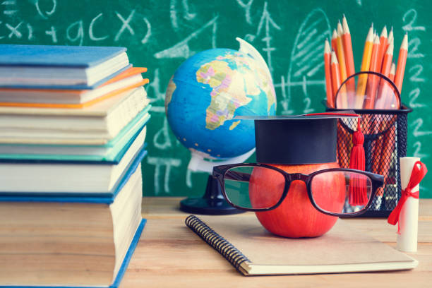 istock Apple Knowledge Symbol and Pencil Books on the desk with board background 927050618