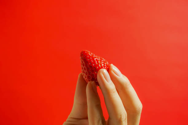 istock A strawberry and hand. Eating a strawberry. 927053920