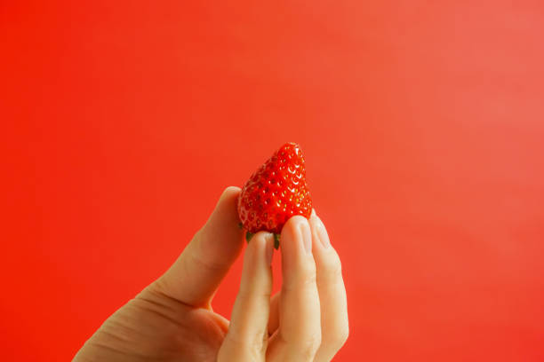 istock A strawberry and hand. Eating a strawberry. 927053924