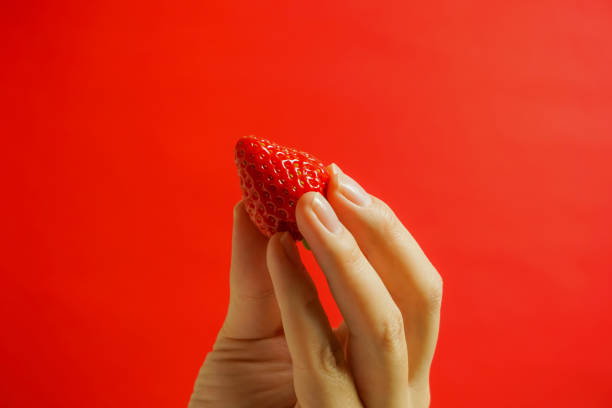 istock A strawberry and hand. Eating a strawberry. 927053926
