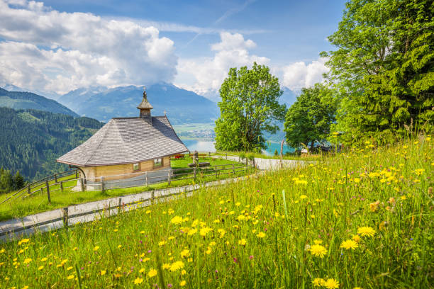 Mountain chapel in the Alps in Zell am See, Austria Panoramic view of beautiful scenery in the Alps with chapel and green meadows full of blooming flowers on a sunny day with blue sky and clouds in springtime, Zell am See, Salzburger Land, Austria winterberg stock pictures, royalty-free photos & images