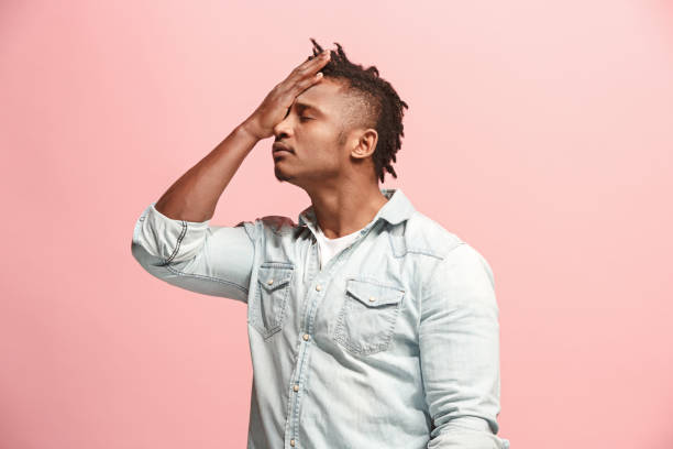 istock African American Man having headache. Isolated over pink background 927057016