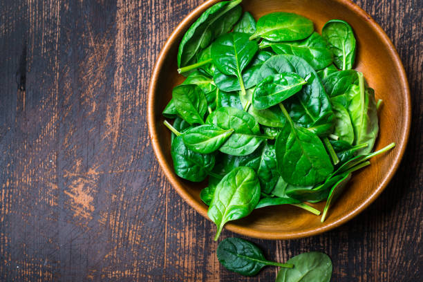 istock Baby spinach leaves in a bowl on dark background 927057500