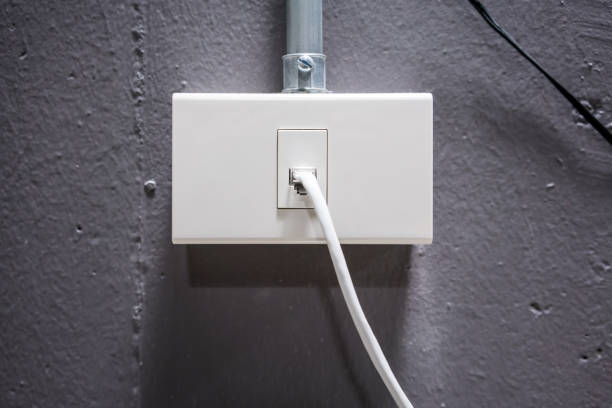 istock Internet cable with white network outlet against grey concrete background 927057560