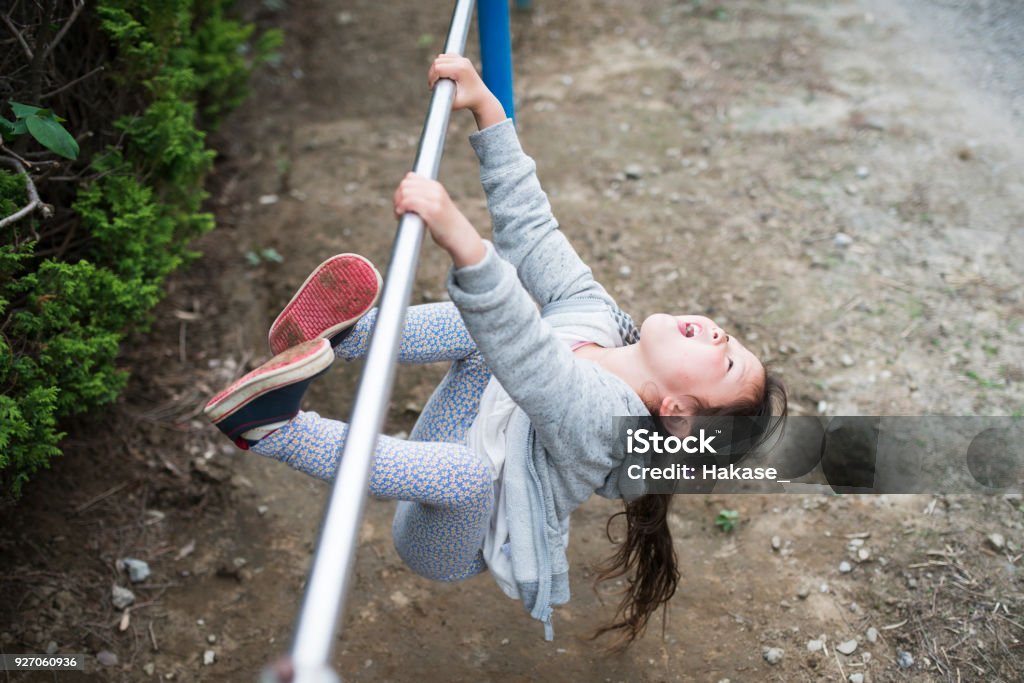 Little girl playing with an iron bar Active Lifestyle Stock Photo